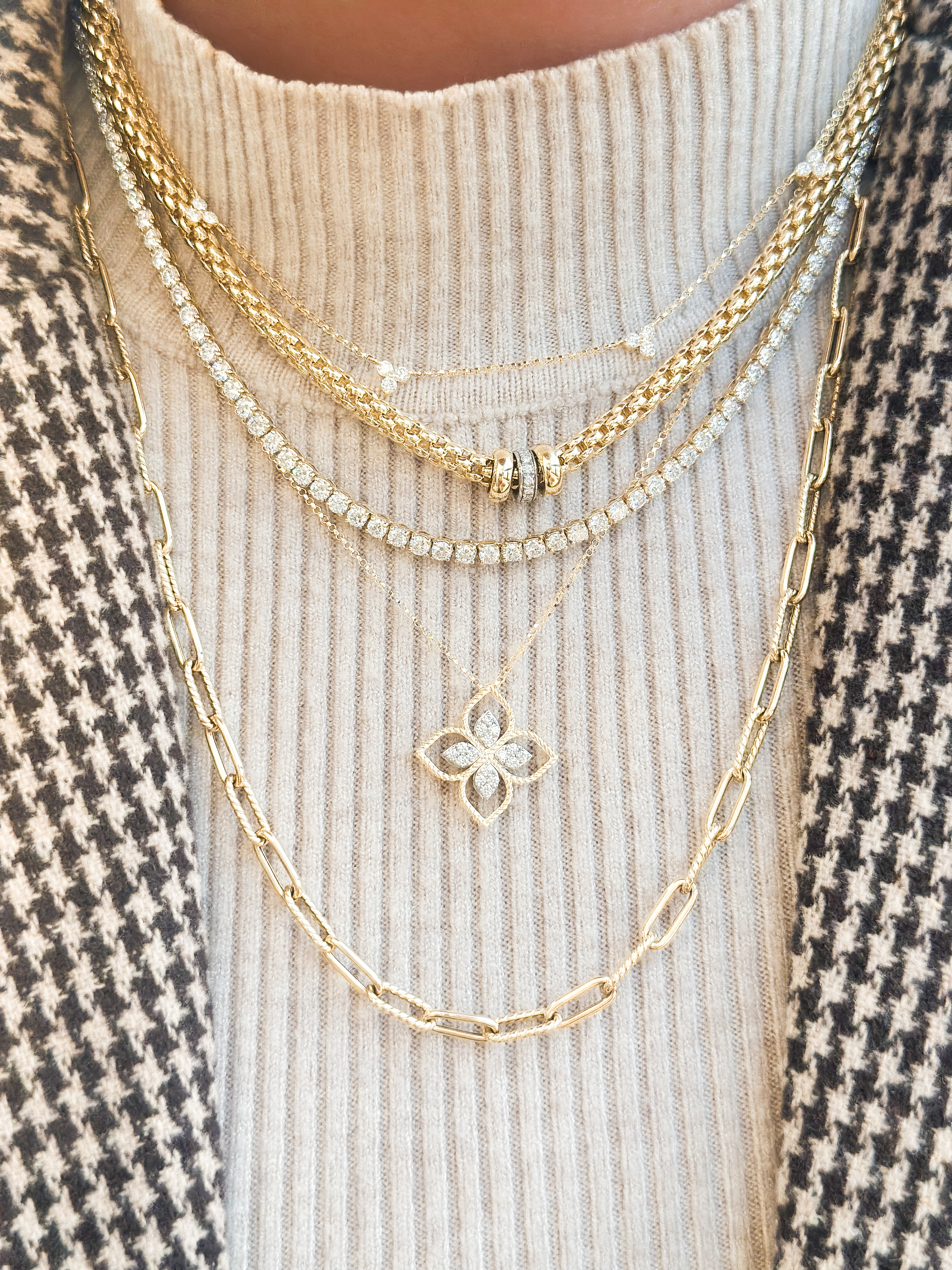 A close-up of a woman’s manicured hand, adorned with three delicate diamond rings.