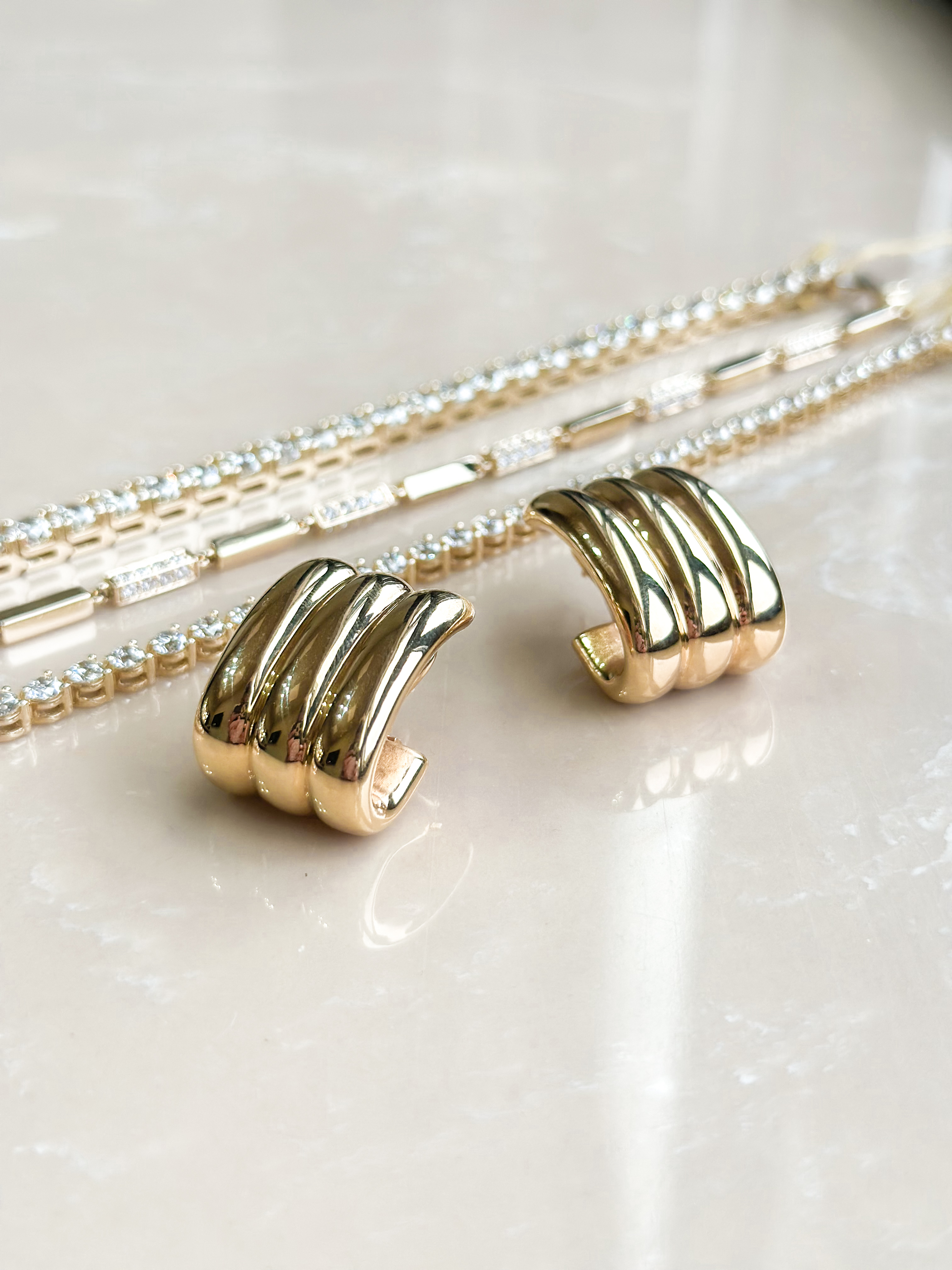 A close-up of a pair of simple yet sparkling diamond stud earrings on a black background.