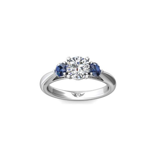 Image title A silver ring with a large central diamond flanked by two smaller blue sapphires.