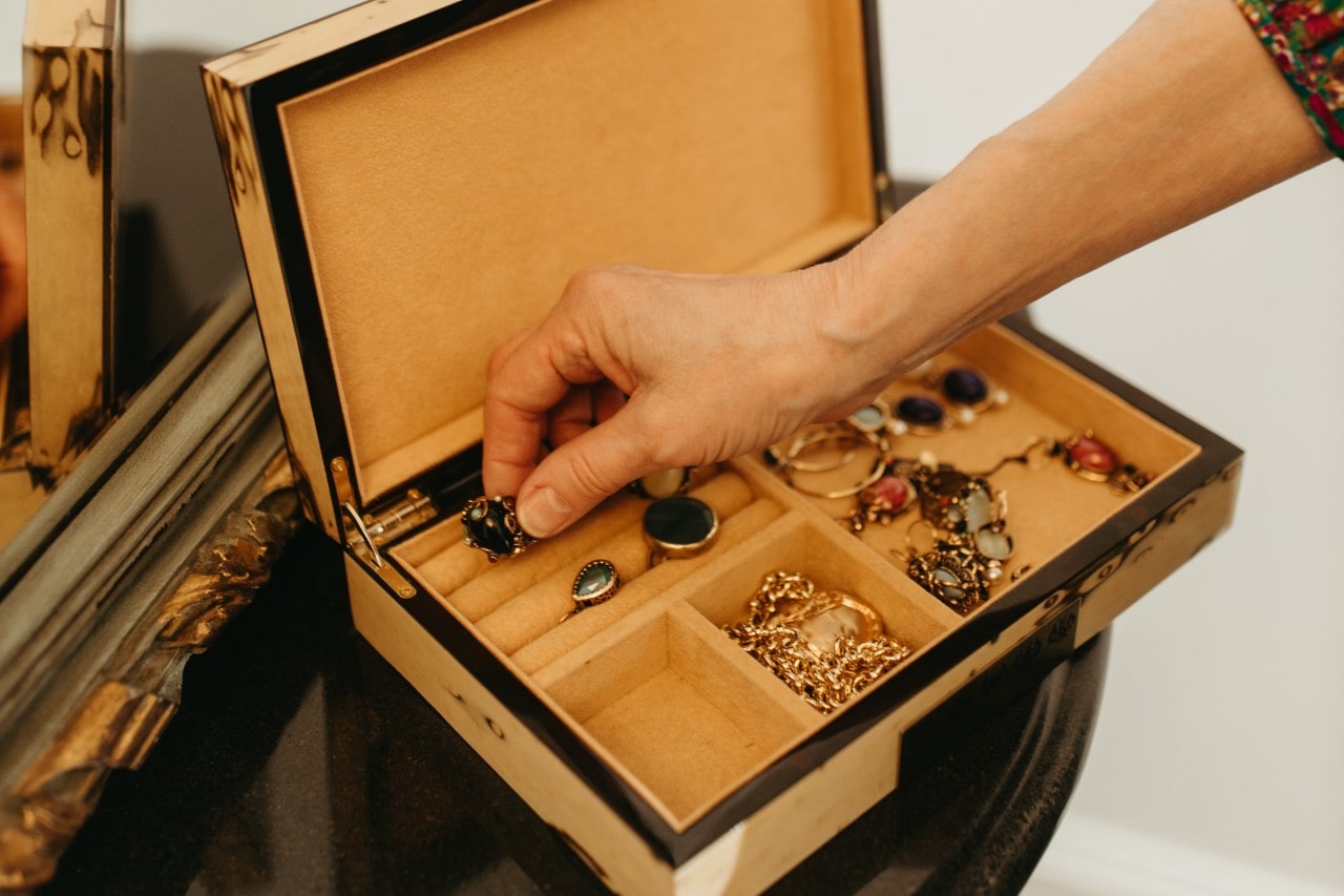 lady’s hand placing jewelry into a box