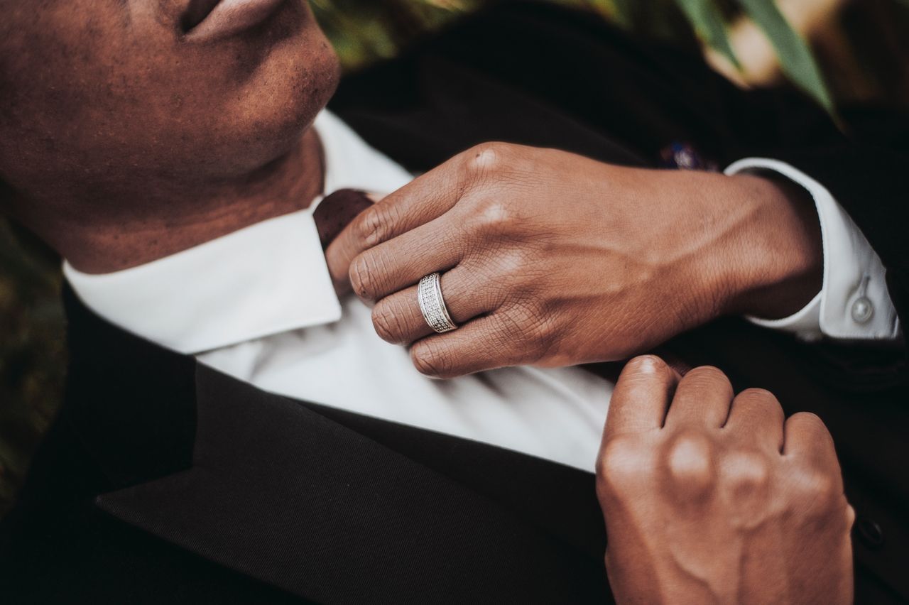 A groom re-adjusts his tie to show off his wedding band from CrownRing