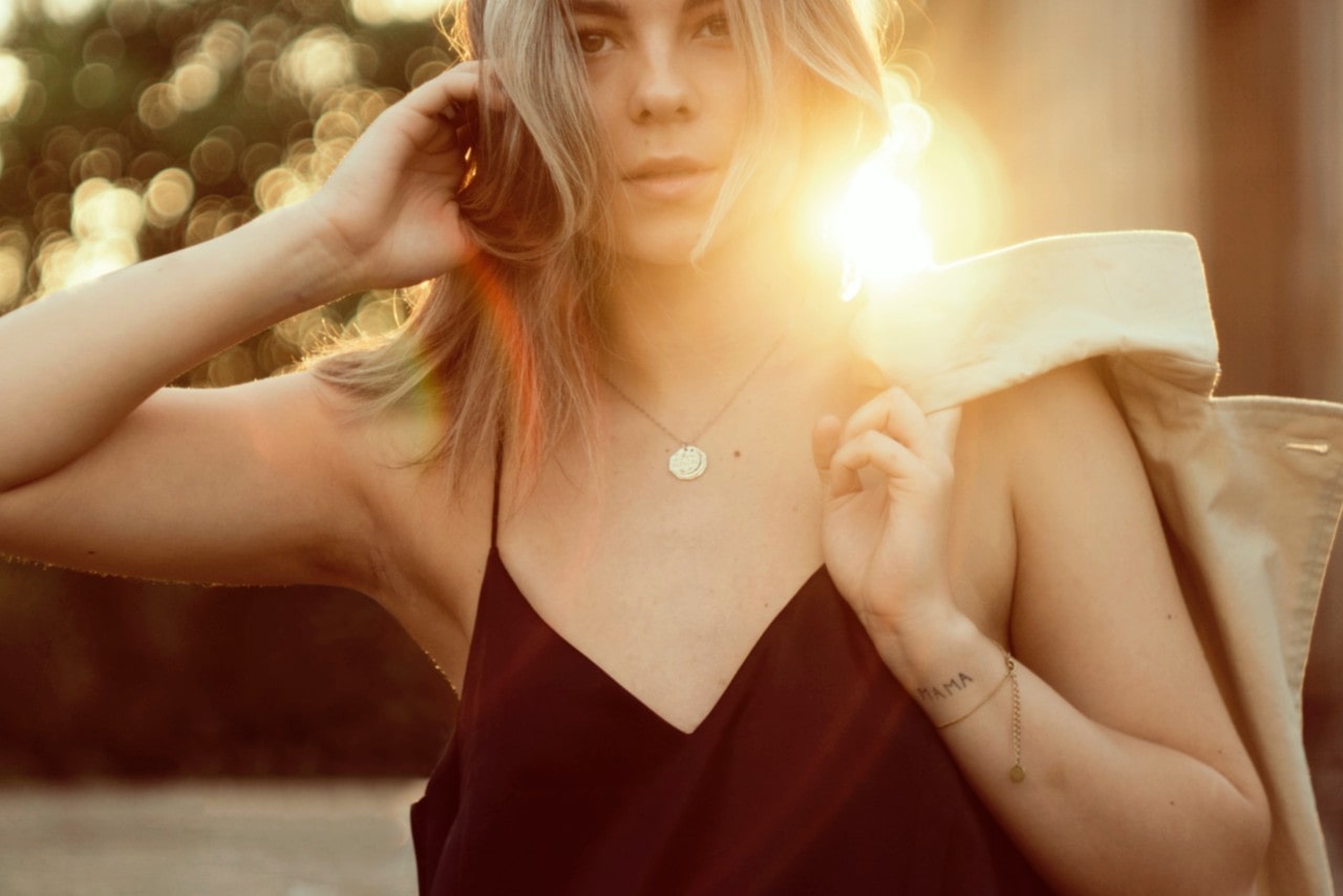 lady standing in the sunlight wearing a dainty necklace