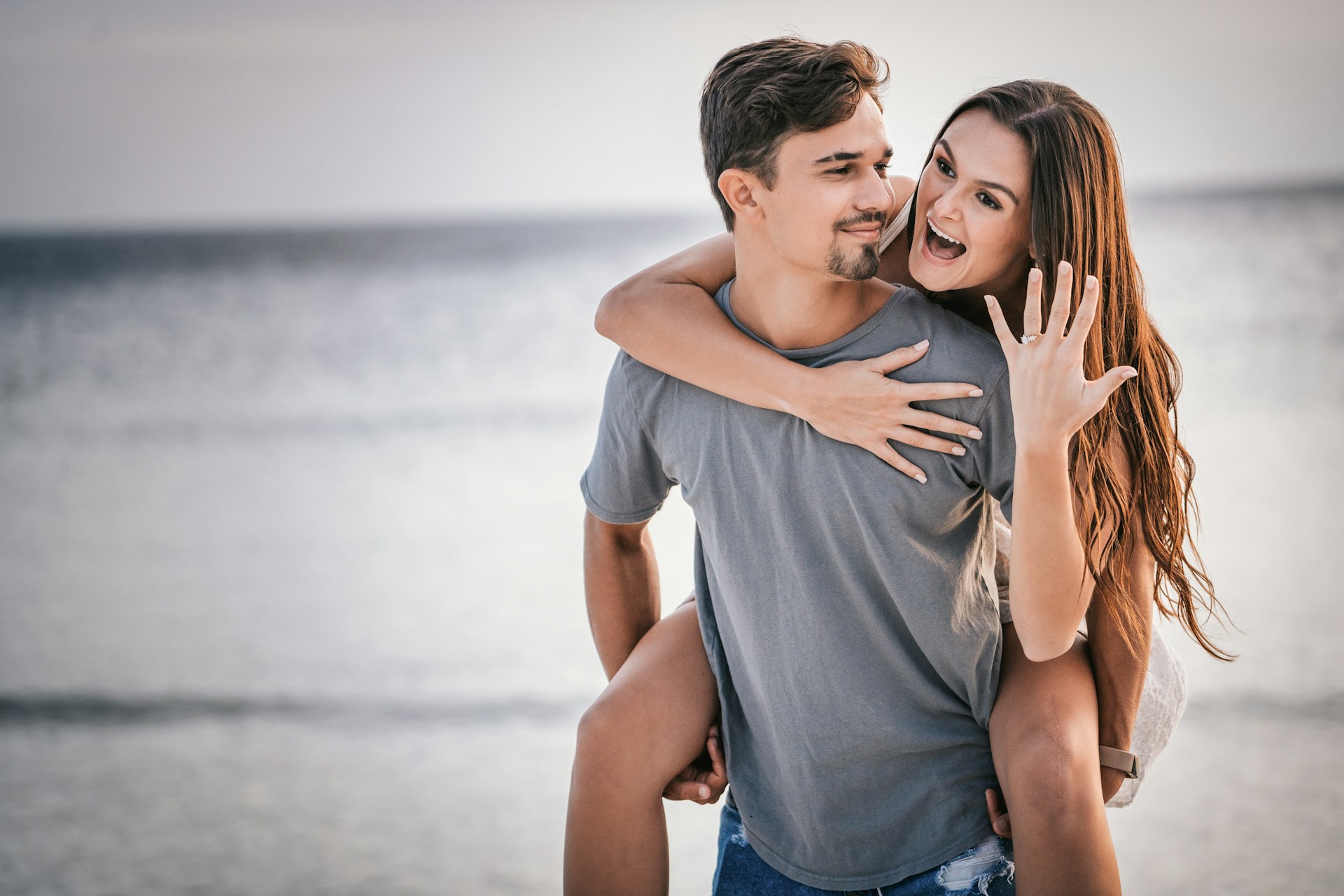 a couple celebrates their recent engagement on the beach. a couple celebrates their recent engagement on the beach.
