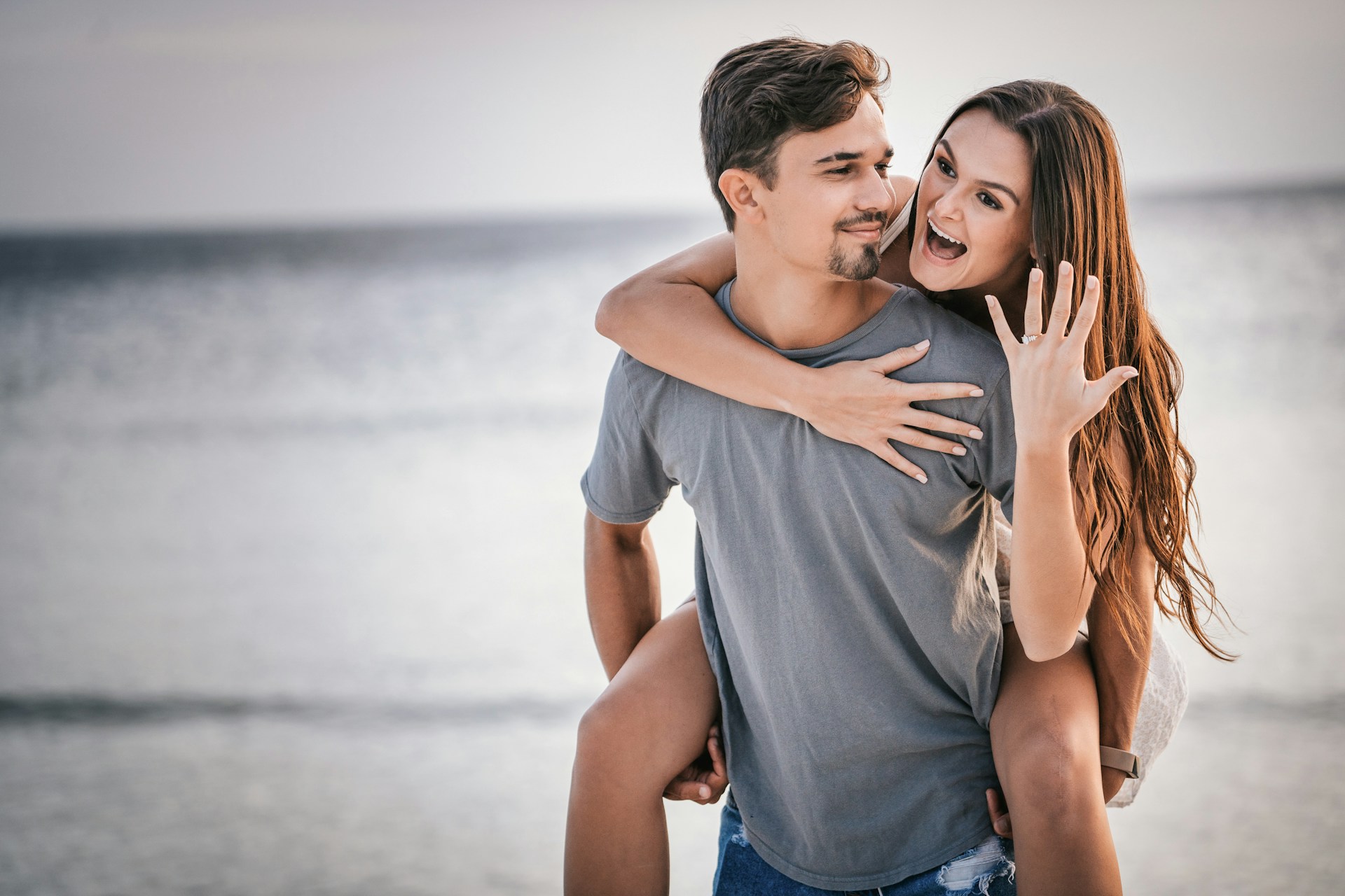 a couple celebrates their recent engagement on the beach.