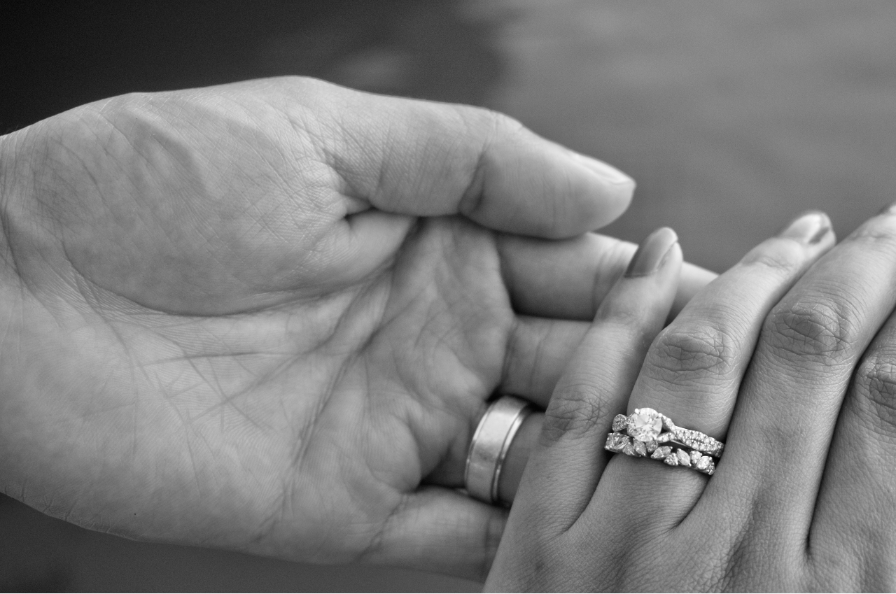 a couple holding hands in black and white – the woman’s hand adorned with a round cut engagement ring a couple holding hands in black and white – the woman’s hand adorned with a round cut engagement ring