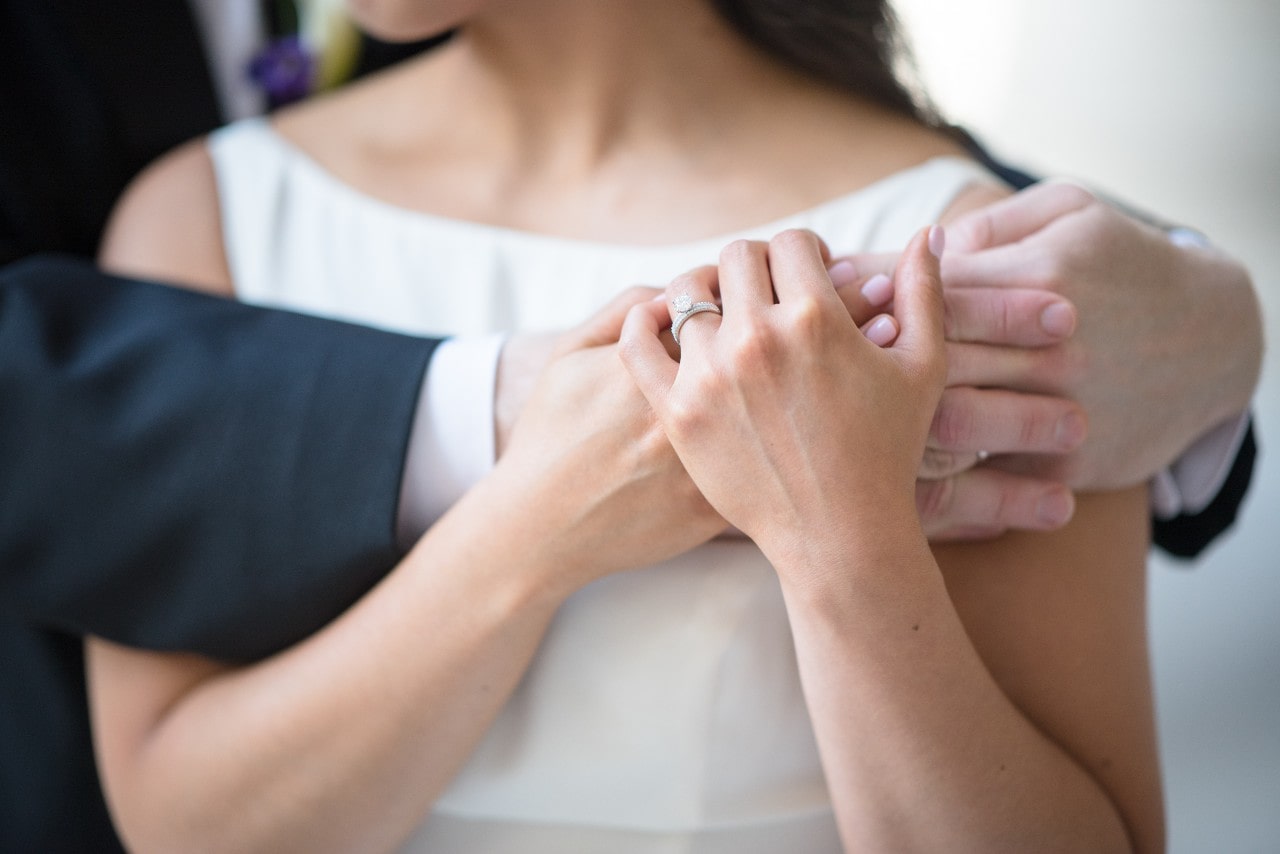 Woman with engagement ring holding hands with fiancee