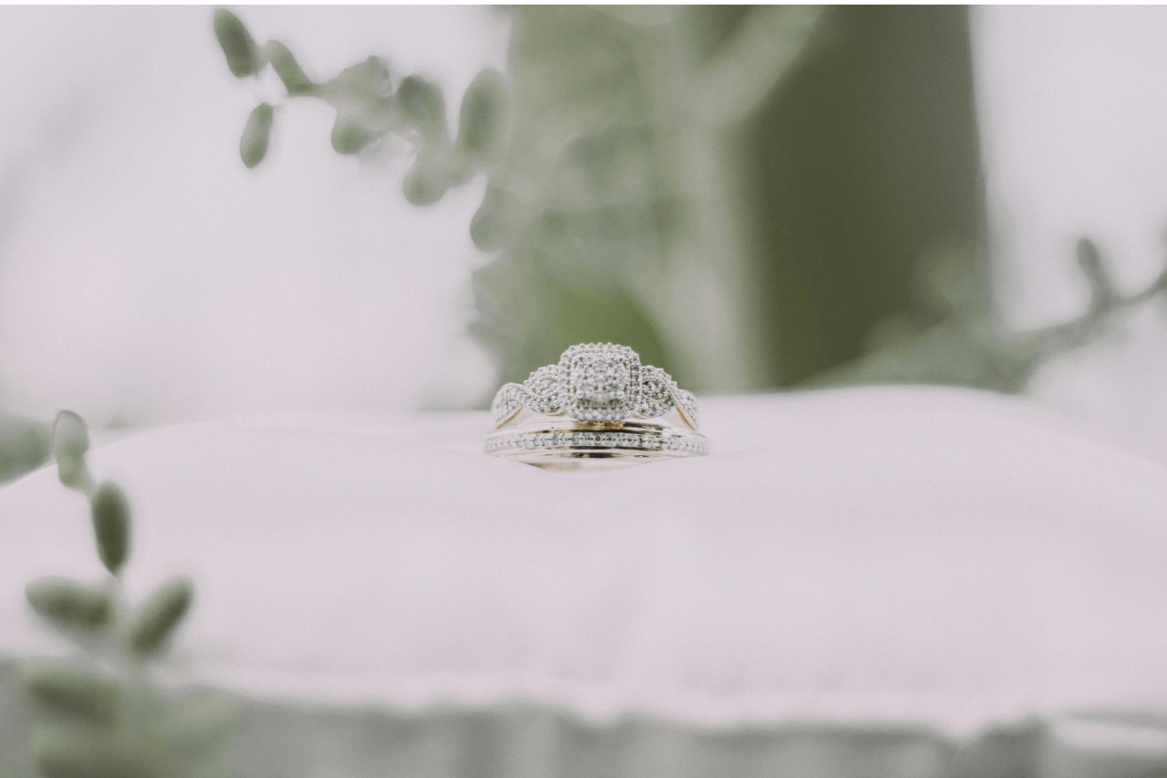 A matching set of bridal rings on a white pillow surrounded by greenery. A matching set of bridal rings on a white pillow surrounded by greenery.